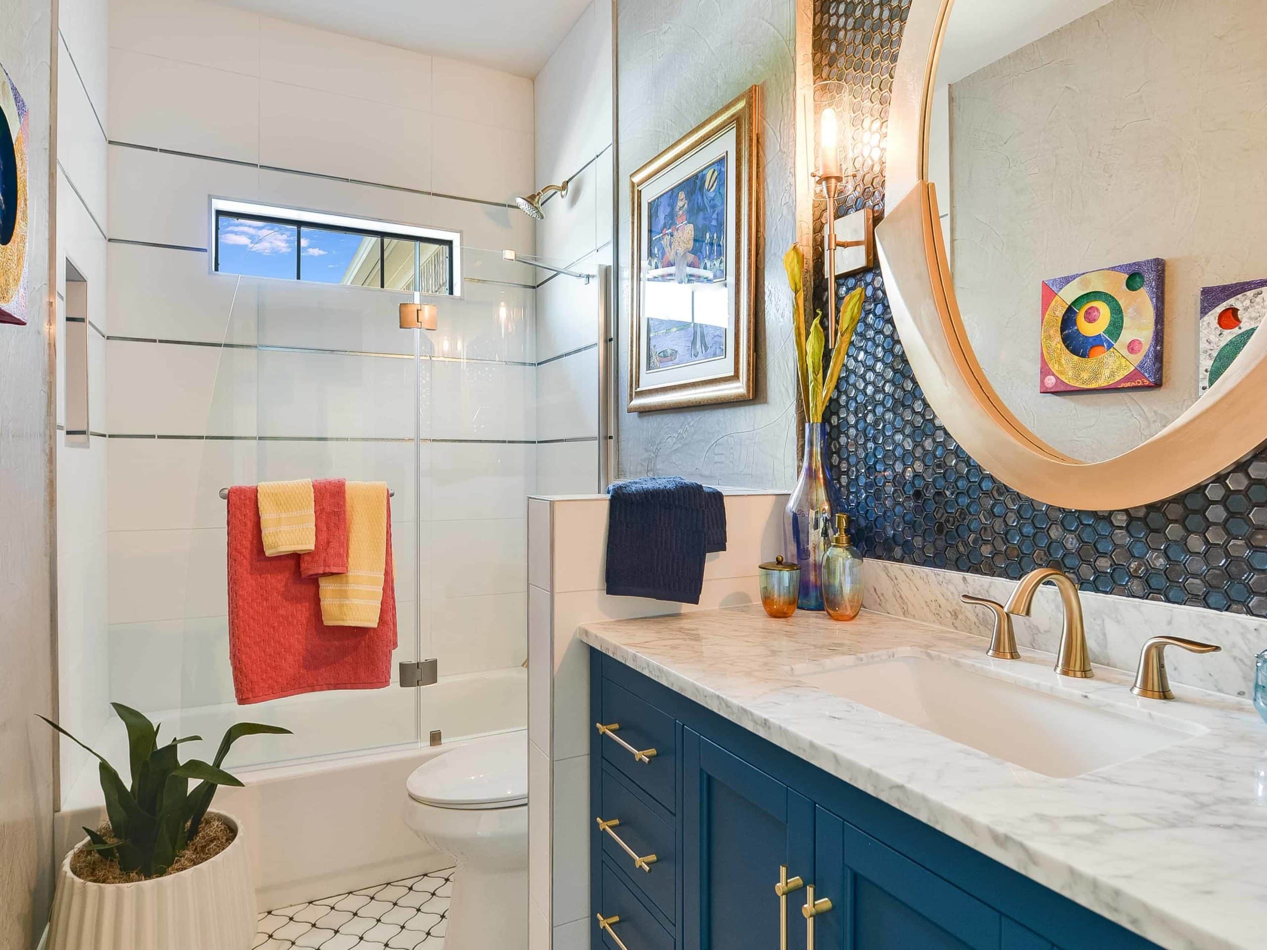 White tile walls and floor, blue mosaic decoration behind the mirror