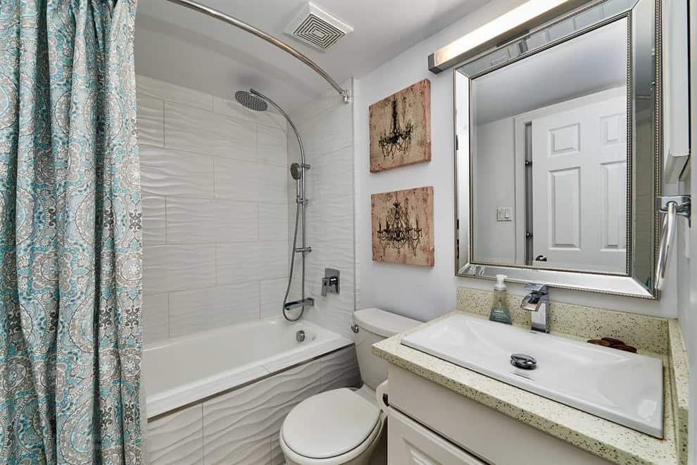 Modern bathroom, white wavy tile walls, white cabinets, quartz countertop