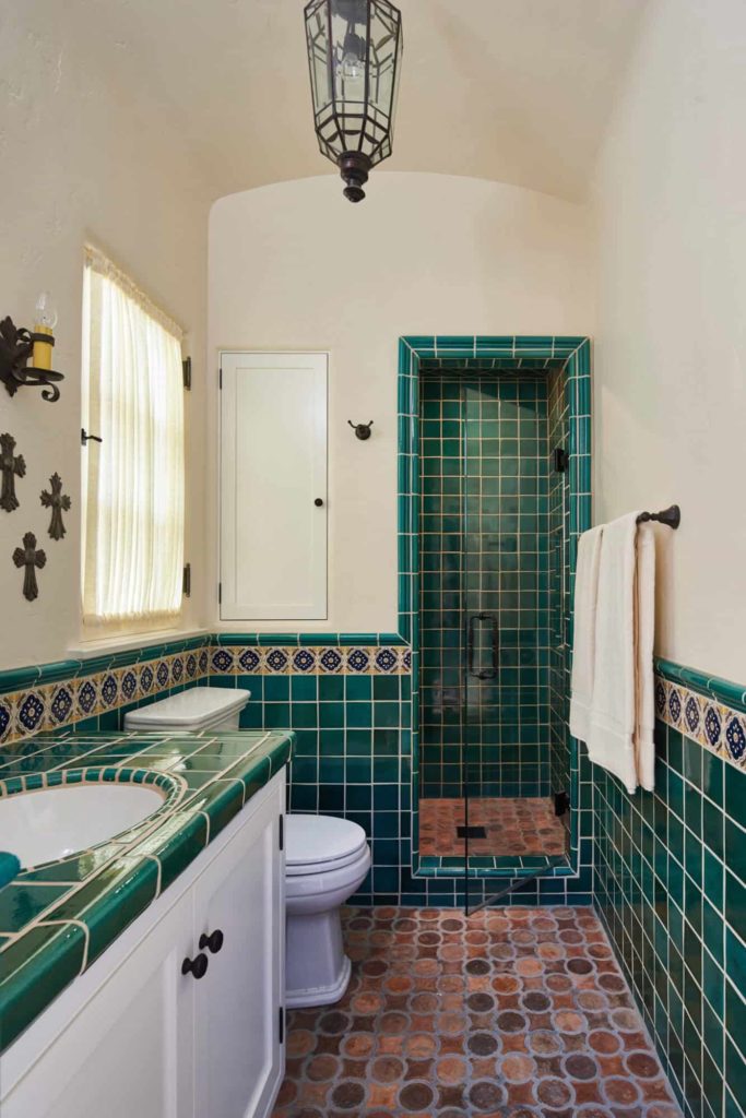 Alcove shower, green tile and beige walls, terracotta floor