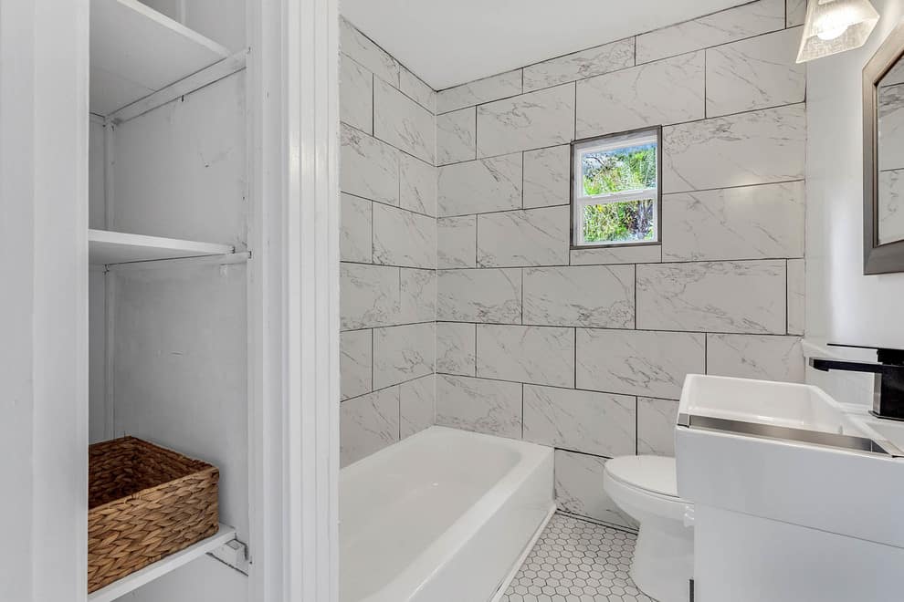 White granite tile walls, white honey comb tile floor, white cabinets