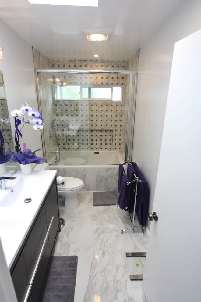 White marble floor, grey pattern tile walls, dark wood cabinets