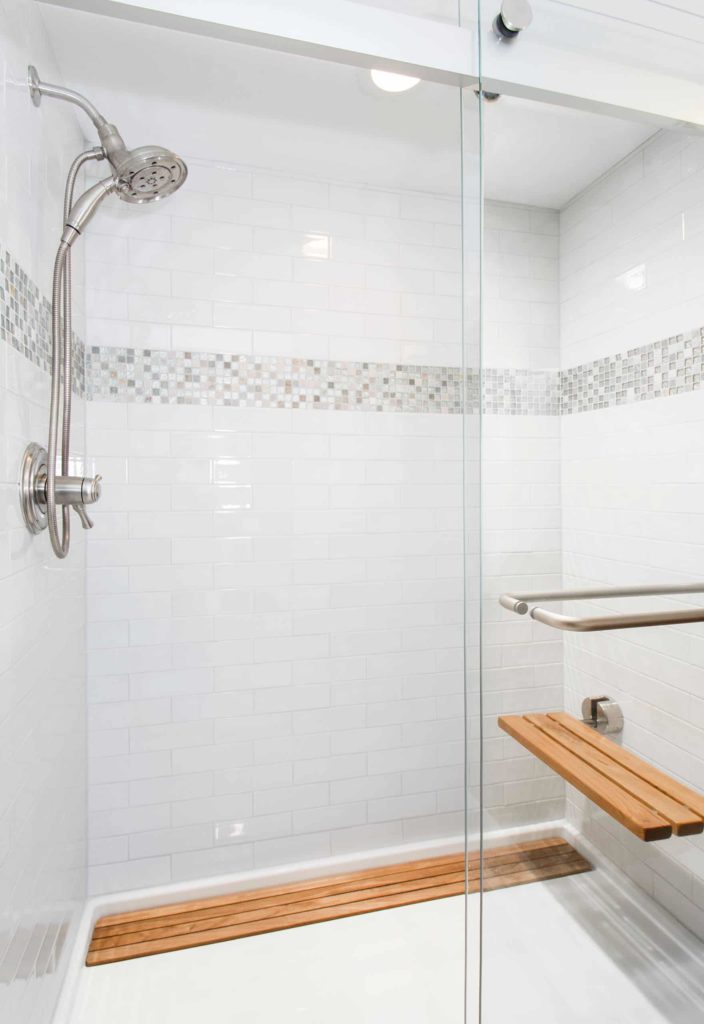 Transitional bathroom with white tile floor and walls, mosaic decoration