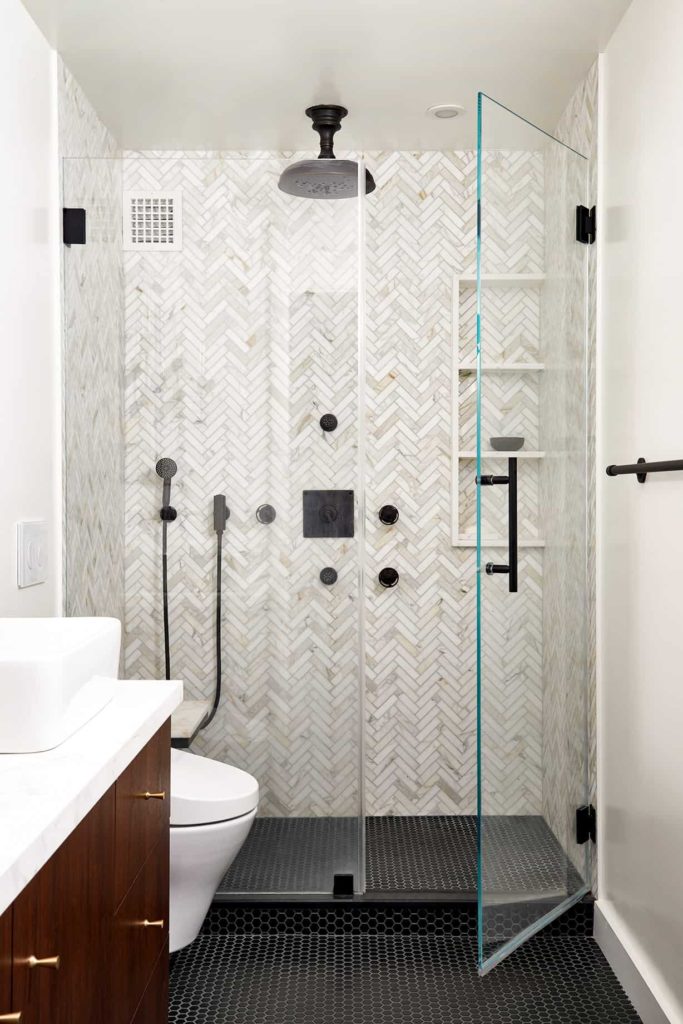 Alcove shower, black tile floor, white and grey mosaic walls