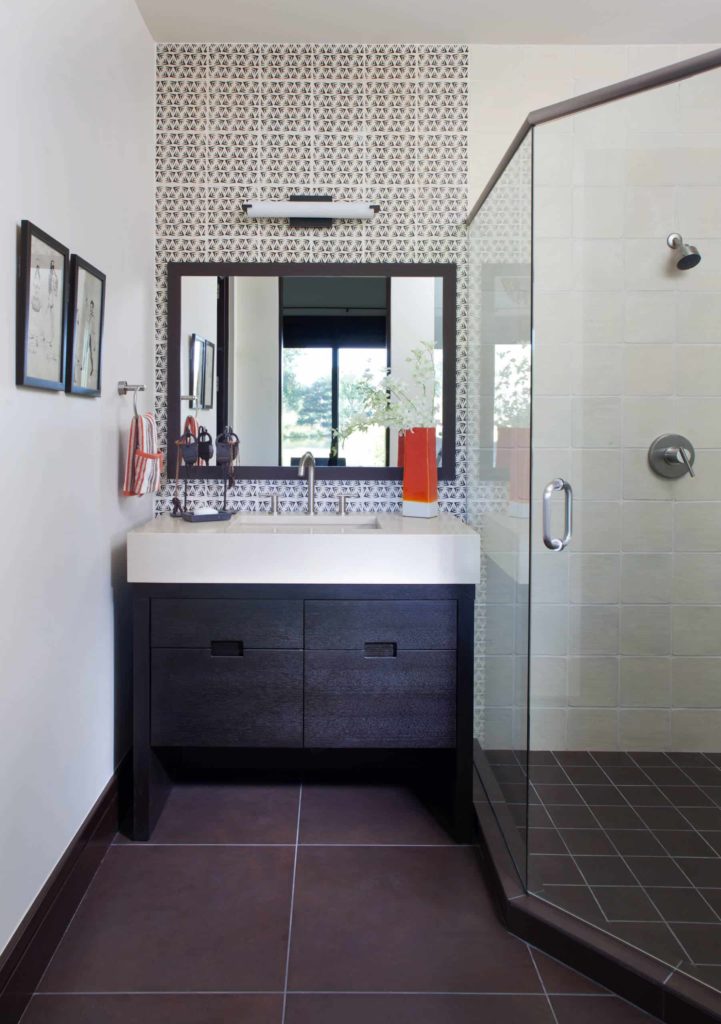 Corner shower, brown tile floor, white walls, dark wood cabinets