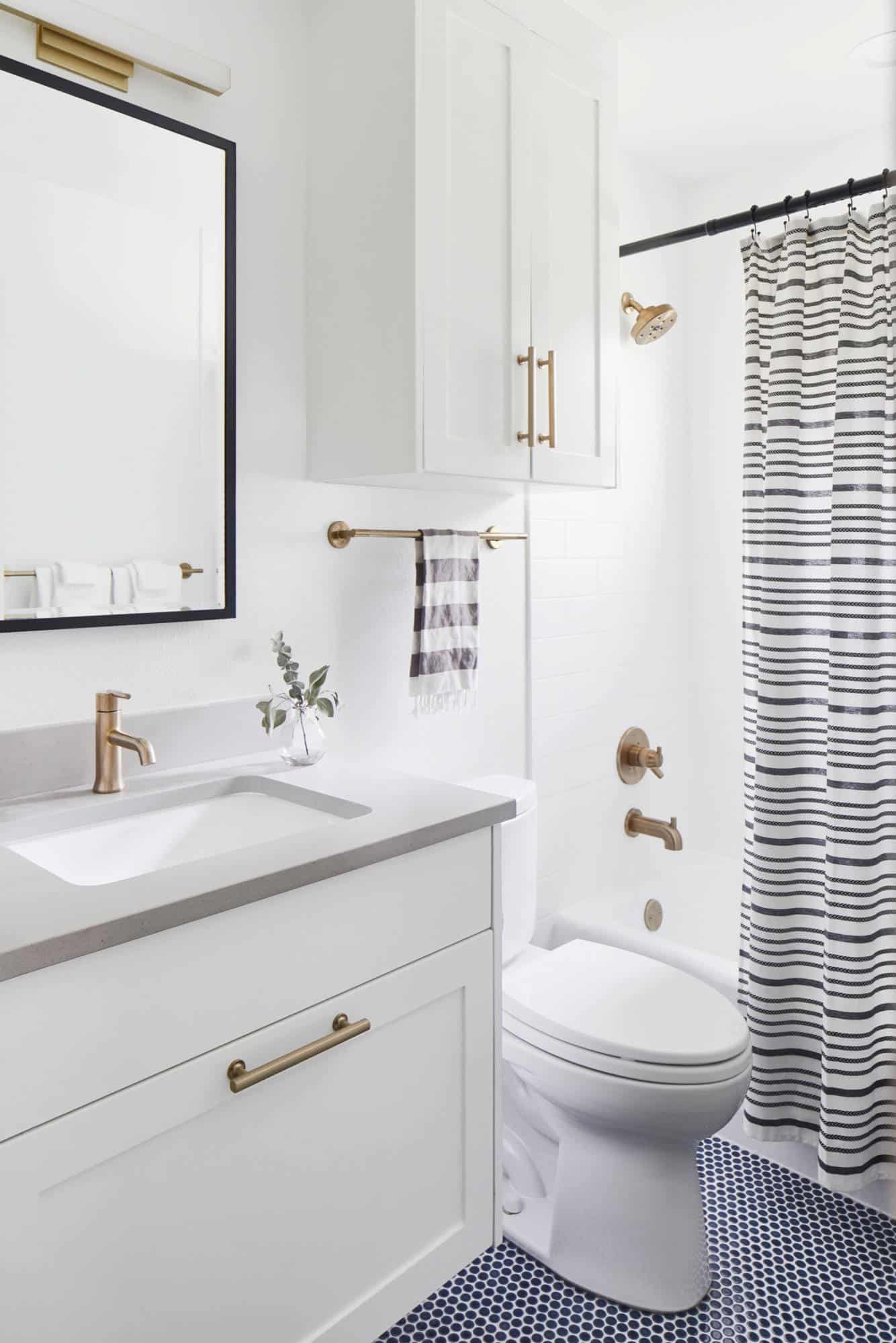 Blue honey comb tile floor, white tile walls, white cabinets