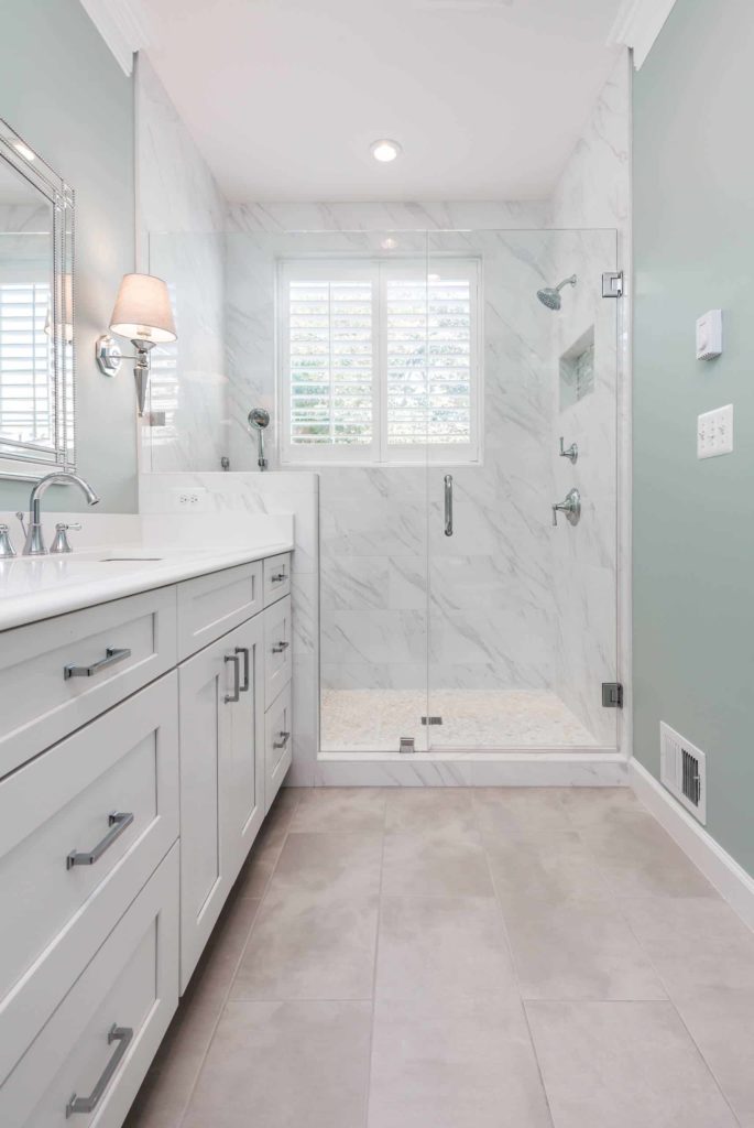 Alcove shower, white marble tiles, white cabinets