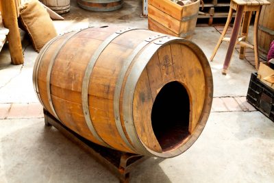Rustic pet house made from a wine or whiskey barrel
