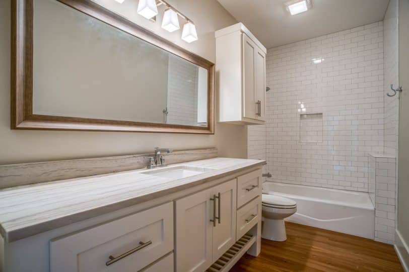 Bathroom - mid-sized traditional kids' white tile and subway tile vinyl floor and beige floor bathroom idea in Austin with shaker cabinets, white cabinets, an undermount sink, quartzite countertops, a two-piece toilet and gray walls