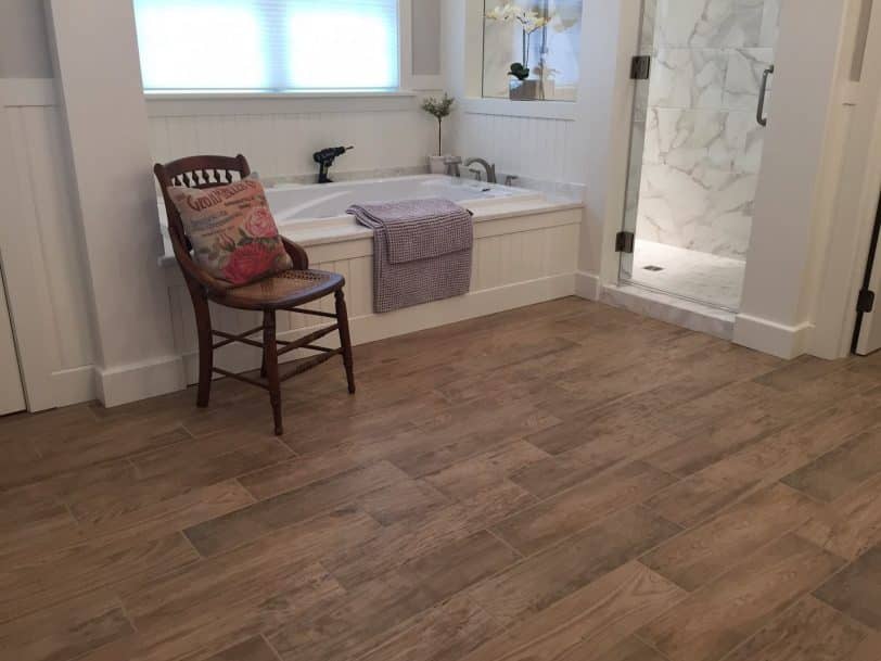 Inspiration for a mid-sized transitional master white tile and ceramic tile brown floor and ceramic tile bathroom remodel in Cincinnati with a hinged shower door and white walls
