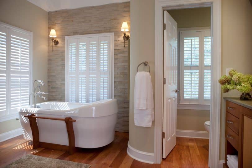Large transitional master medium tone wood floor freestanding bathtub photo in Philadelphia with medium tone wood cabinets and beige walls