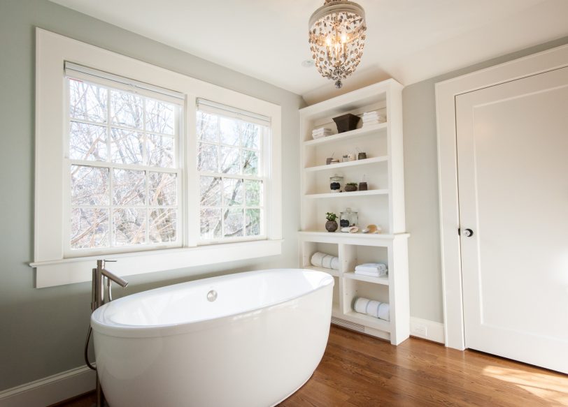 Example of a mid-sized transitional master medium tone wood floor and brown floor freestanding bathtub design in Atlanta with gray walls