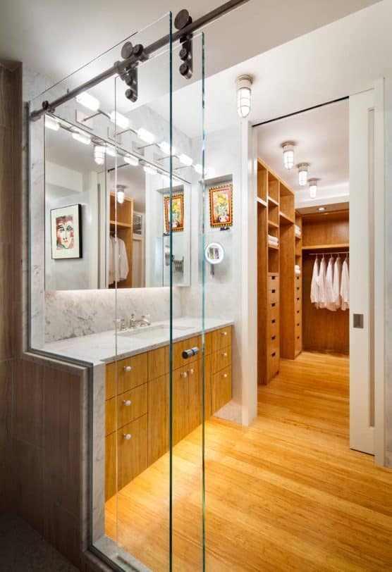 Inspiration for a small contemporary master white tile and stone slab bamboo floor bathroom remodel in New York with flat-panel cabinets, medium tone wood cabinets, an undermount sink, a wall-mount toilet, marble countertops and white walls