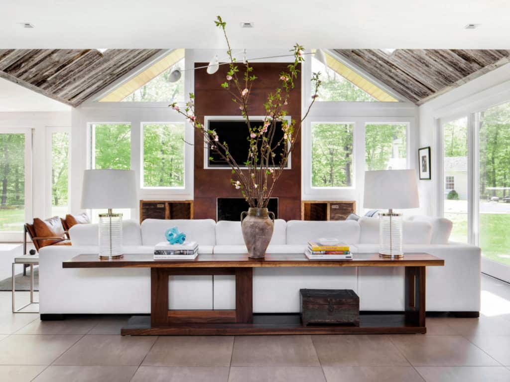 Grand living room with a long sofa table adorned with a vase and double lamps